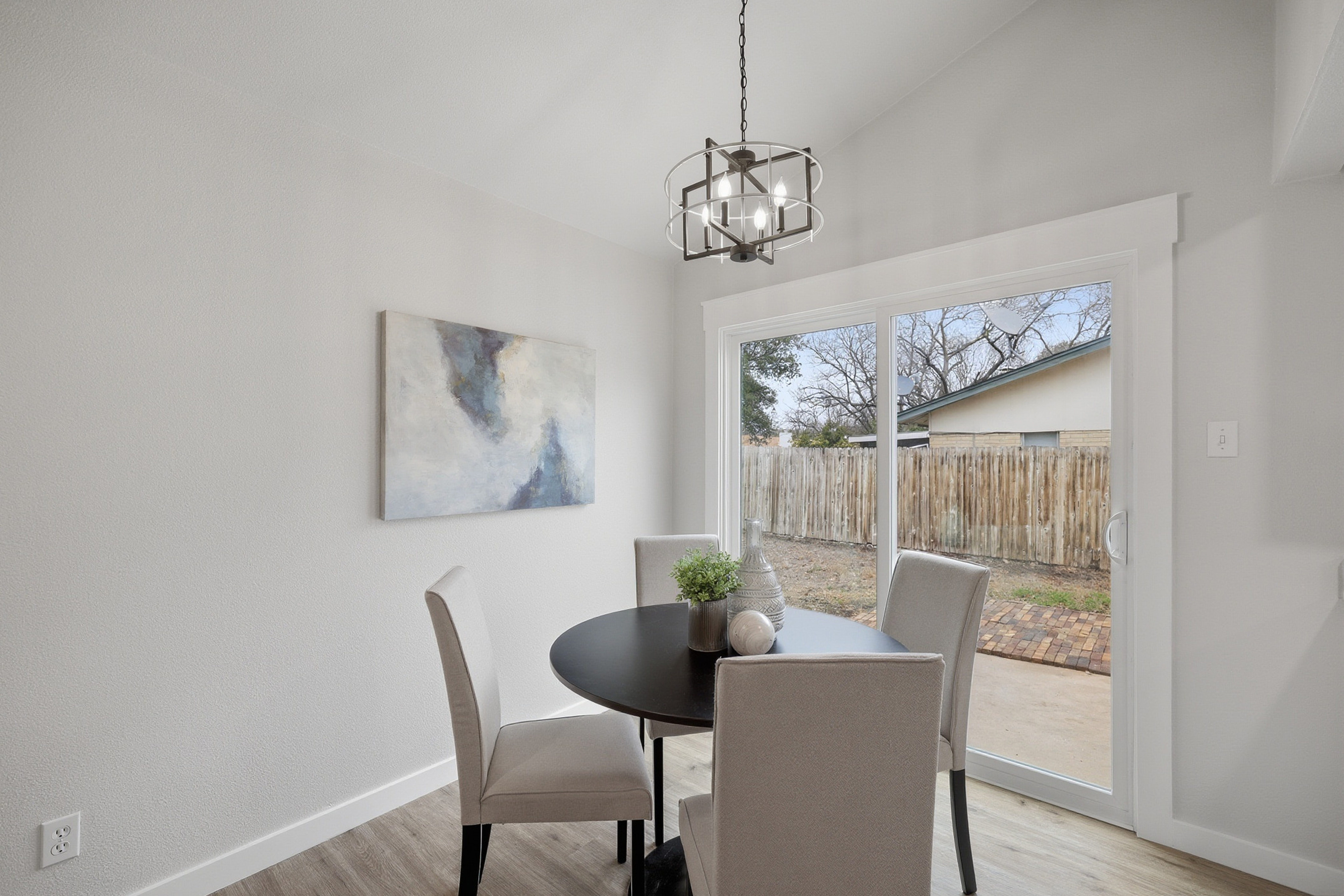 Breakfast nook with round dining table, chandelier, and sliding glass door to backyard